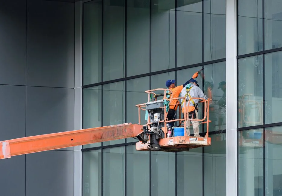 An individual disinfects a workspace using fumigation, wearing full protective gear for safety.